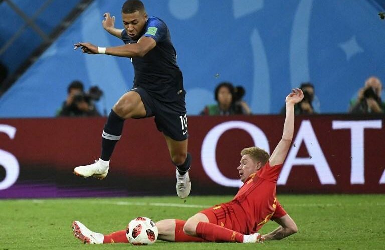 Kylian Mbappé saute par-dessus la jambe tendue de Kevin De Bruyne lors de la demi-finale de la Coupe du monde 2018.