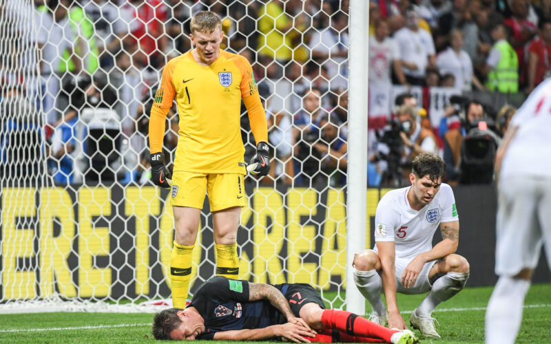Le gardien de but anglais Jordan Pickford regarde un joueur allongé sur le sol.