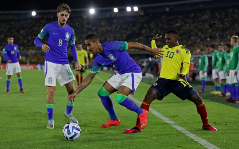 Een speler van Brazilië kijkt toe hoe zijn ploegmaat in duel gaat met een speler van Colombia.